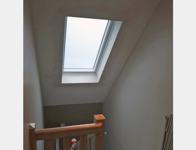 Pose d'une fenêtre Velux dans une cage d'escalier